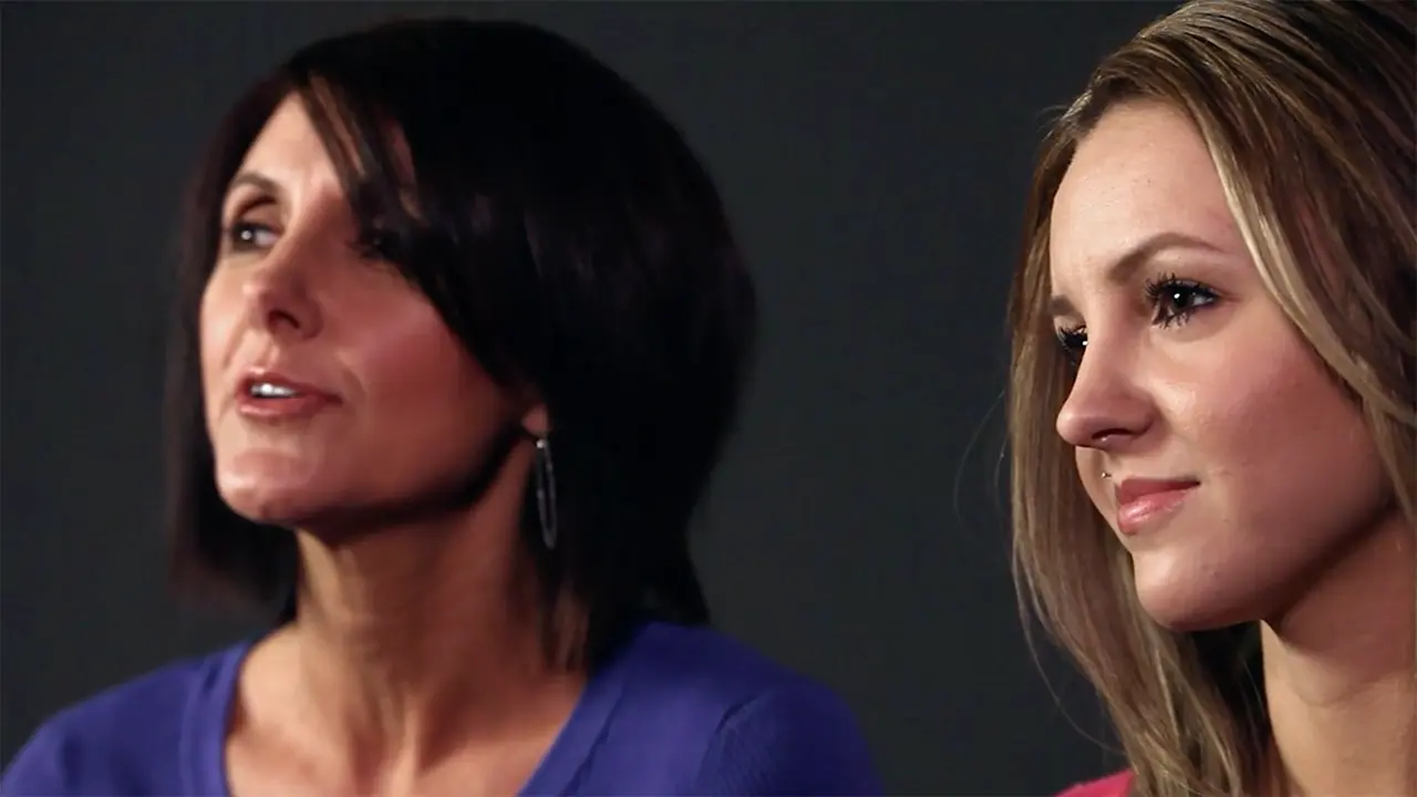 Mother and daughter sitting next to each other.
